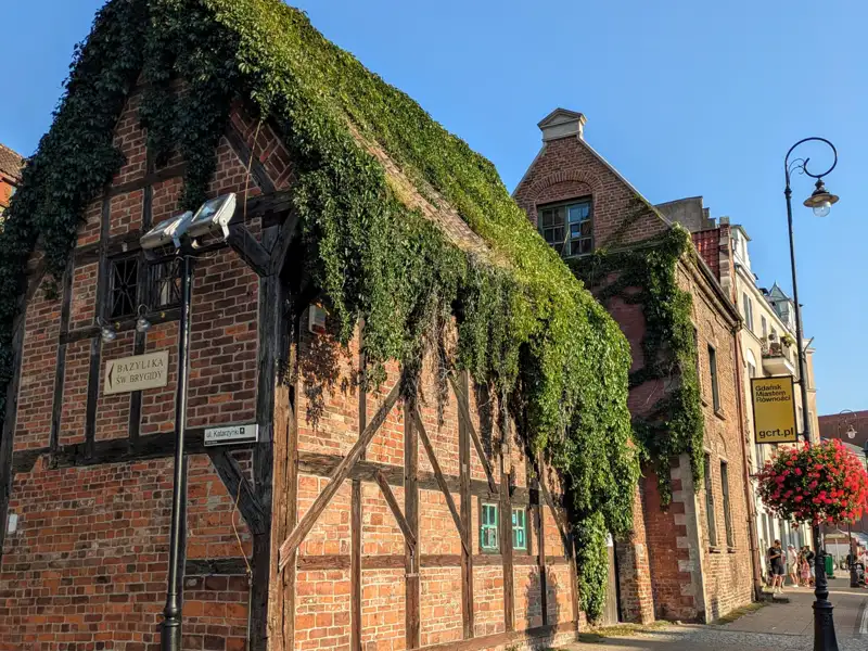 Altes Backsteingebäude, überwachsen mit Efeu, möglicherweise ein historisches Gebäude.