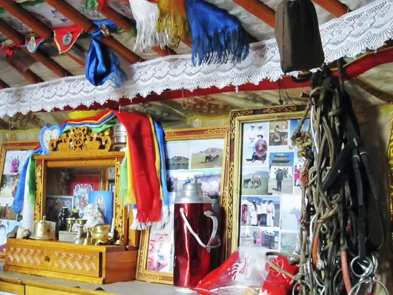 Hausaltar und Familienfotos im Inneren einer Jurte.