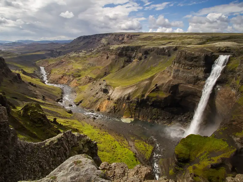 Spektakulärer Wasserfall, der in eine felsige Schlucht stürzt und von einem Fluss durchflossen wird.