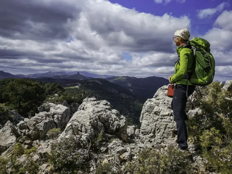 Wanderer auf einem Berggipfel mit Blick auf das Tal.