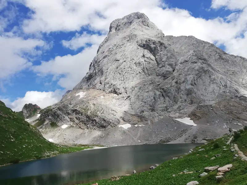 Imposanter Berg mit See im Vordergrund.