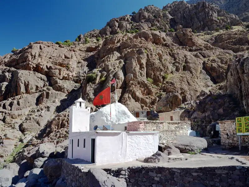 Weißes Gebäude mit marokkanischer Flagge in den Bergen