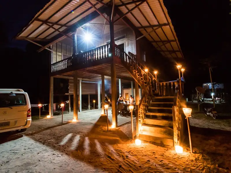 Nachtaufnahme der Unterkunft, beleuchtet von Fackeln.