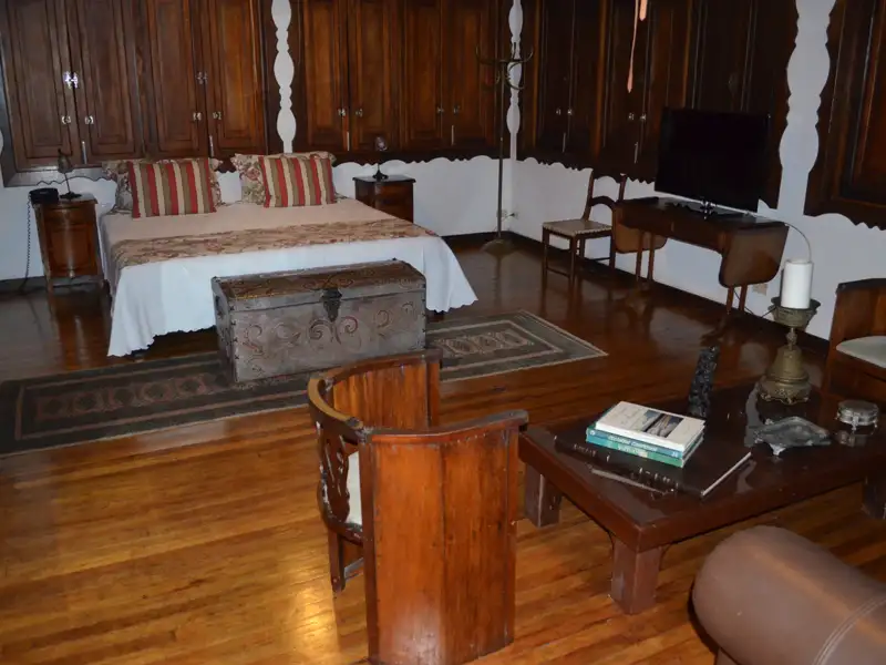 Hotelzimmer mit Doppelbett, Holzmöbeln und Sitzbereich.