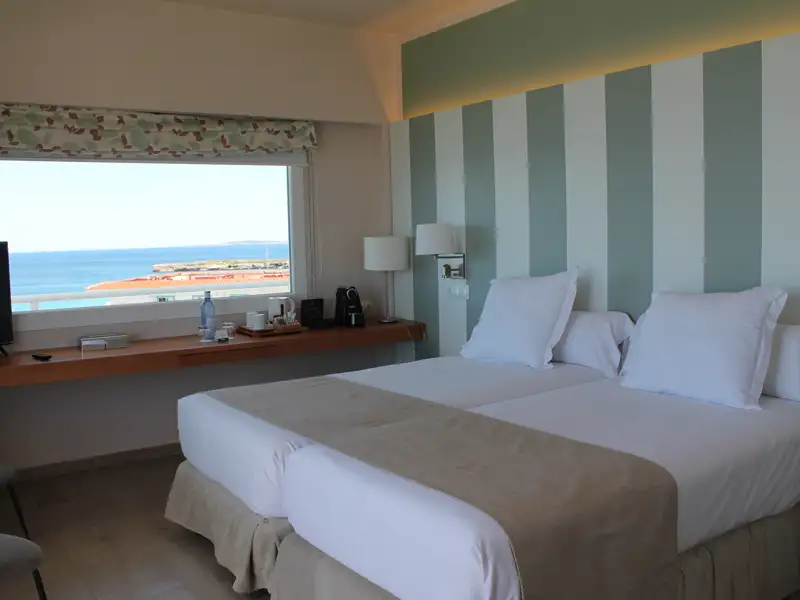 Hotelzimmer mit zwei Betten und Meerblick.