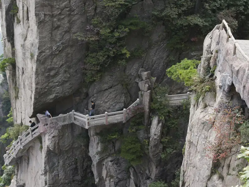 Wanderer auf einem schmalen Weg an einer Klippe.