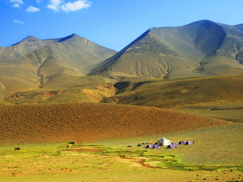 Basislager mit Zelten in einer bergigen Landschaft.