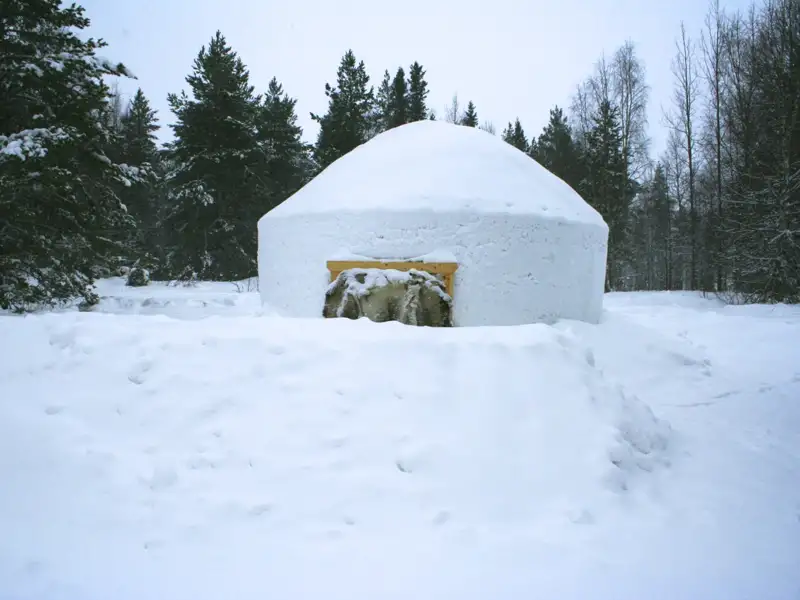 Eine Schneehütte im Winterwald.