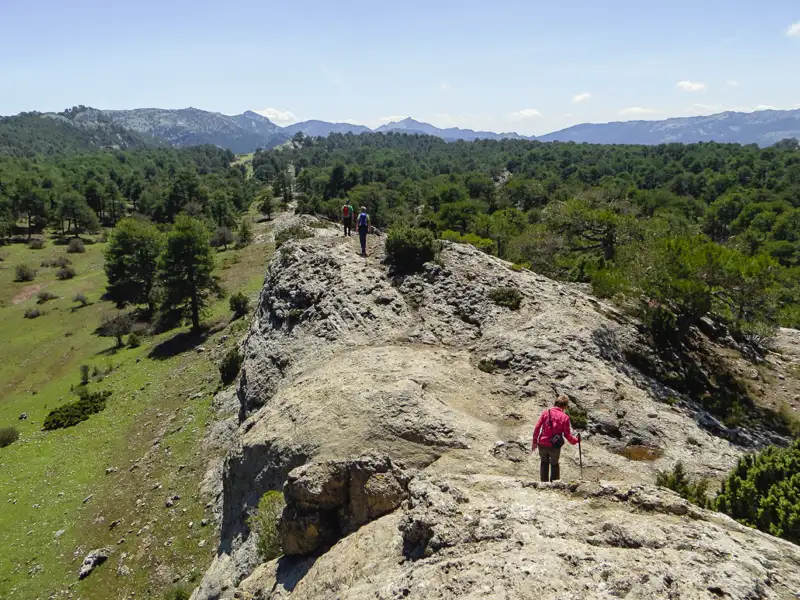 Wanderer auf einem felsigen Grat inmitten einer Berglandschaft.