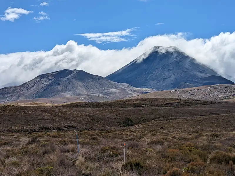 Zwei Berge in einer Landschaft, einer davon teilweise von Wolken verdeckt.