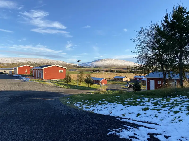 Unterkunft mit roten Häusern und schneebedeckten Hügeln im Hintergrund.