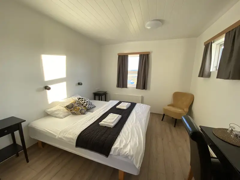 Schlafzimmer mit Doppelbett und Sitzgelegenheiten.