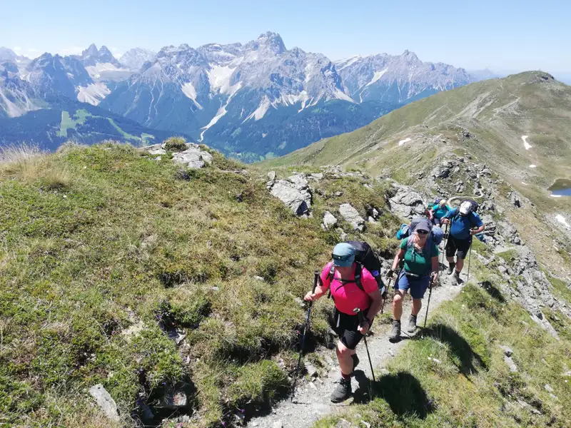 Wandergruppe auf einem Bergpfad in den Alpen.