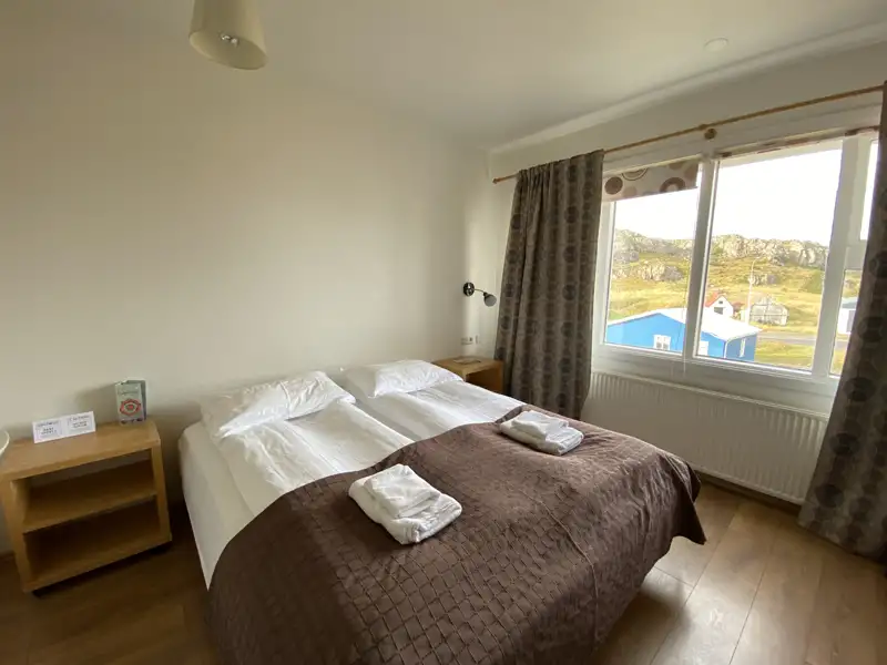 Doppelbett im Hotelzimmer mit Blick auf die Landschaft.