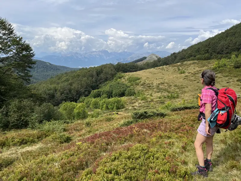 Wanderer auf einem Bergpfad mit Blick auf eine Bergkette.