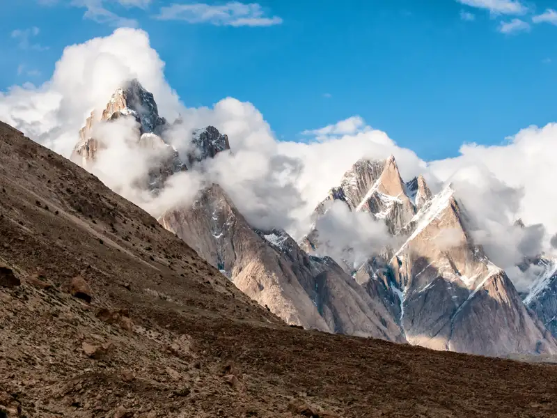 Beeindruckende Berglandschaft mit schneebedeckten Gipfeln und Wolkenformationen.