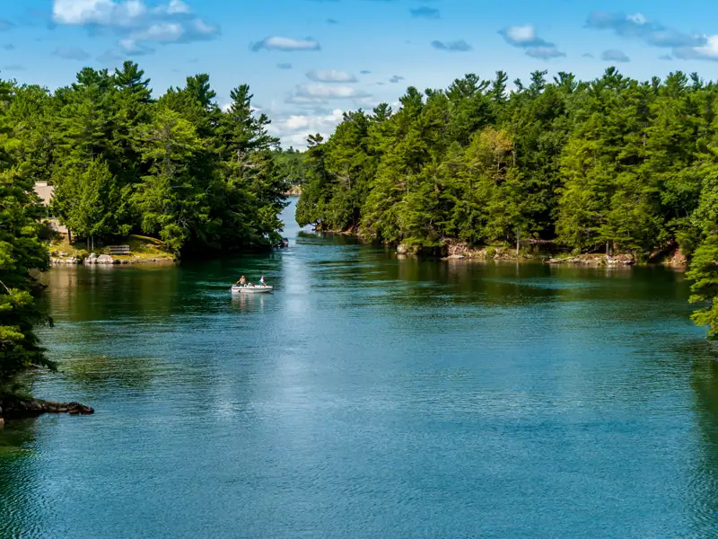 Boot auf einem Fluss zwischen bewaldeten Inseln