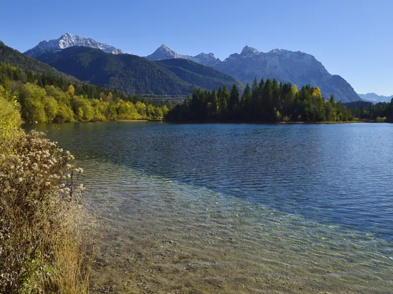 Klares Wasser des Bergsees mit Blick auf die schneebedeckten Bergspitzen.