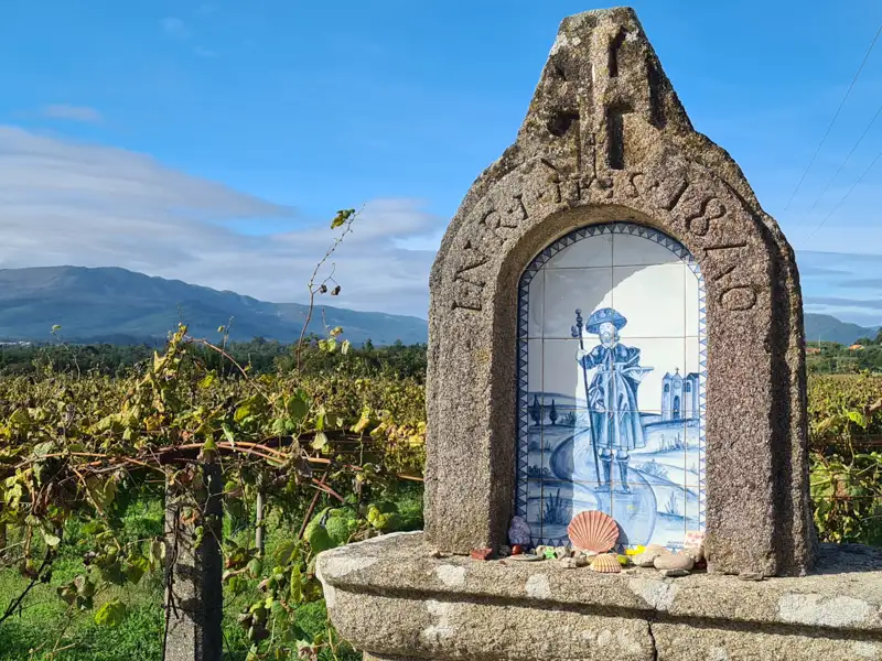 Heiligen Jakobus Schrein, der den Pilgern auf dem Jakobsweg den Weg weist, umgeben von Weinbergen und mit Blick auf die Berge.