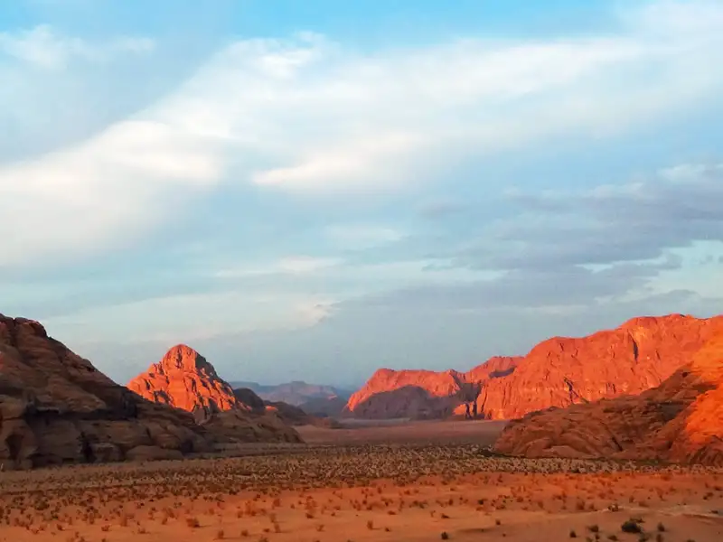 Panorama der Wüste mit im Sonnenuntergang beleuchteten Felsen.