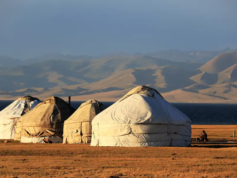Traditionelle mongolische Jurtenbehausungen in einer weiten Landschaft.