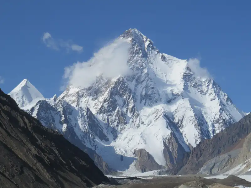 Schneebedeckte Bergkette unter blauem Himmel.
