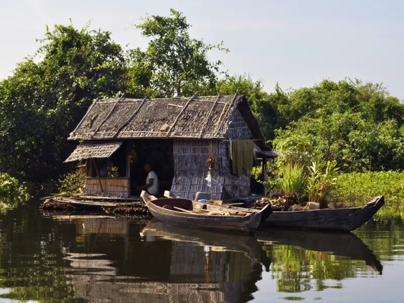 Kambodscha Radreise. Traditionelles schwimmendes Haus, umgeben von Bäumen und Pflanzen.