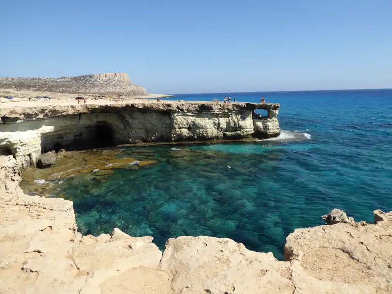 Felsige Küstenformation mit klarem, türkisfarbenem Wasser.