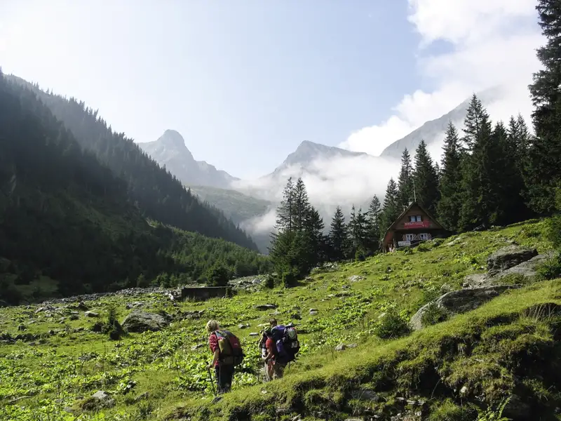 Wanderer auf dem Weg zu einer Berghütte in den Bergen.
