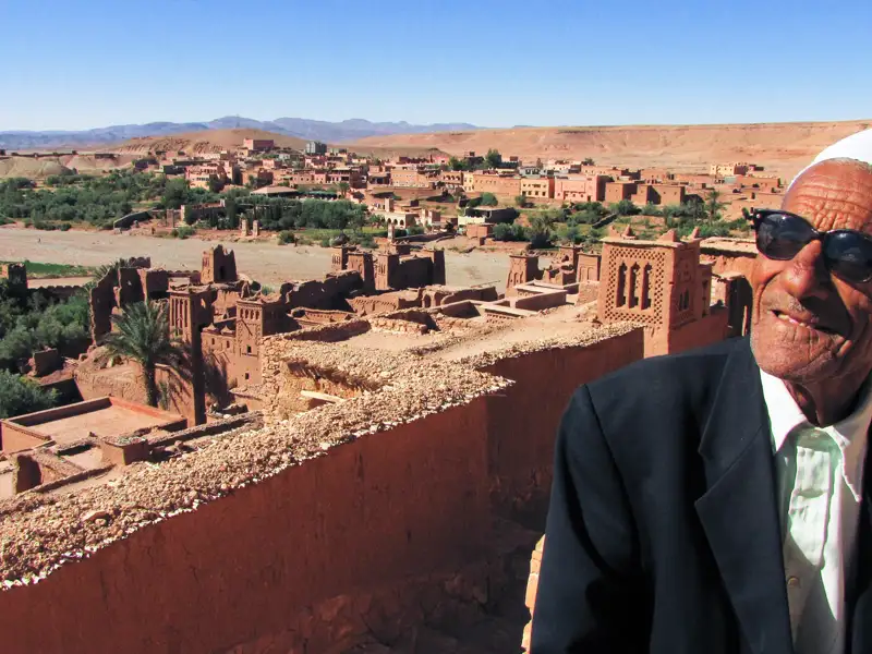 Ein lokaler Bewohner vor der Kulisse der historischen Lehmbausiedlung.