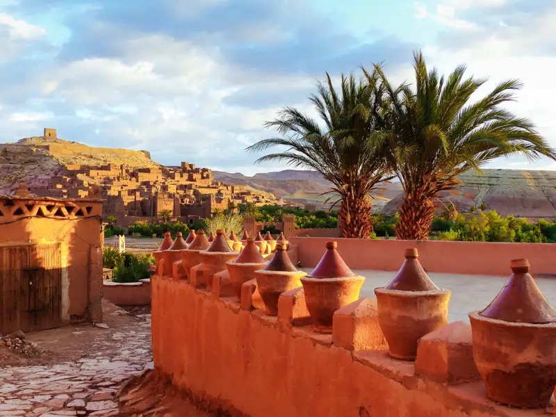 Dachterrasse mit Tongefäßen und Blick auf Ait Benhaddou, eine UNESCO-Welterbestätte in Marokko.