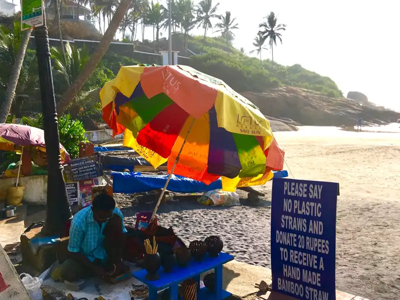 Verkäufer am Strand bietet handgemachte Bambusstrohhalme als nachhaltige Alternative zu Plastik an.
