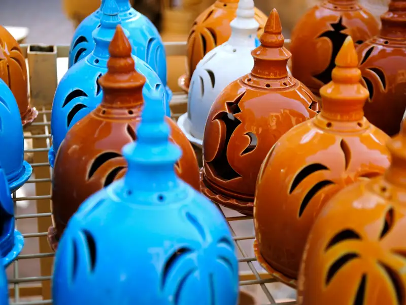 Keramiklampen in verschiedenen Farben, ausgestellt auf einem Markt.
