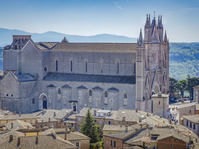 Der Dom von Orvieto, eine beeindruckende Kathedrale in Italien, mit seiner charakteristischen Fassade aus schwarz-weißen Marmorstreifen.