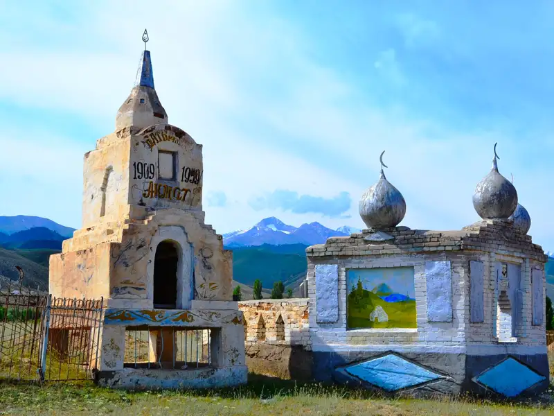 Historische Gebäude mit islamischer Architektur und Berglandschaft im Hintergrund.