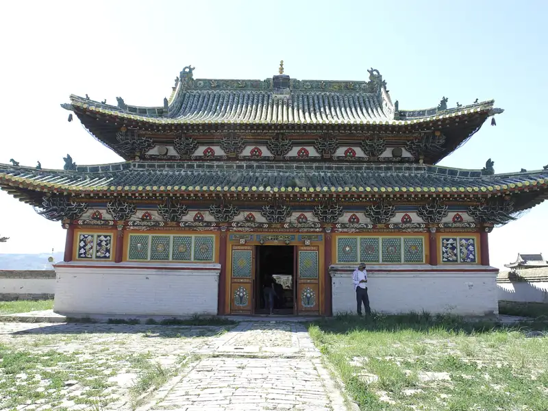 Traditionelles mehrstöckiges Gebäude mit grünen Dach und Verzierungen.