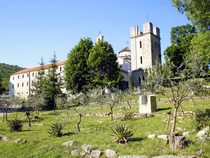 Historisches Kloster mit Glockenturm und Garten.