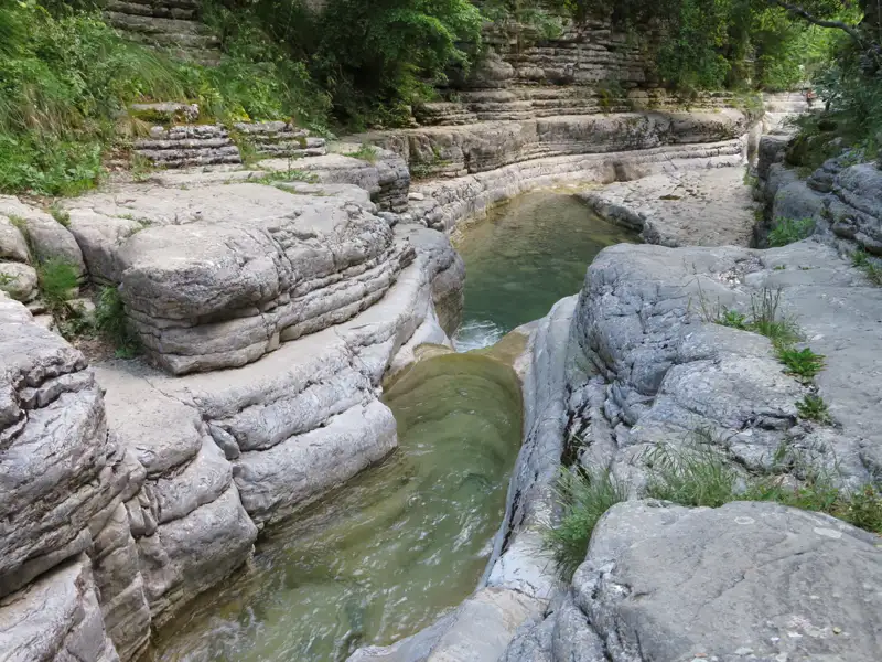 Fließendes Wasser in einer Schlucht mit ausgeprägten Felsformationen.