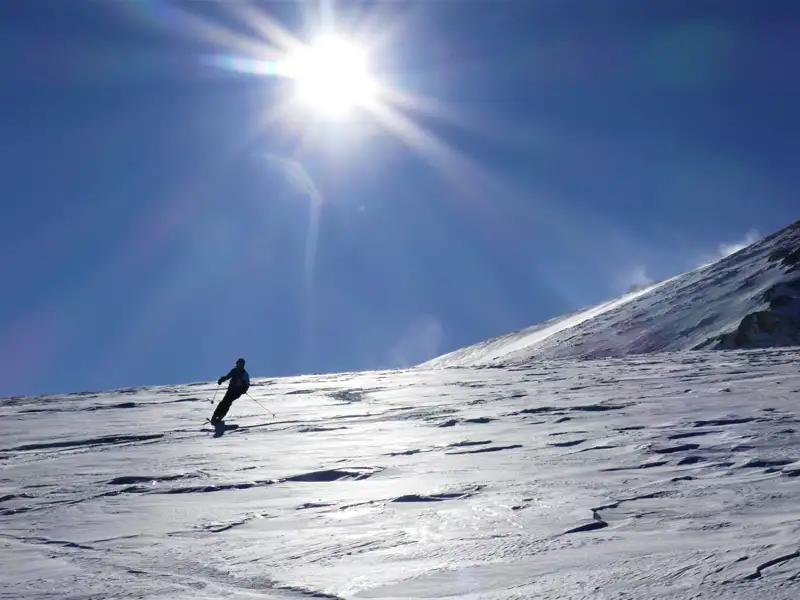 Skifahrer auf einer sonnigen Skipiste.