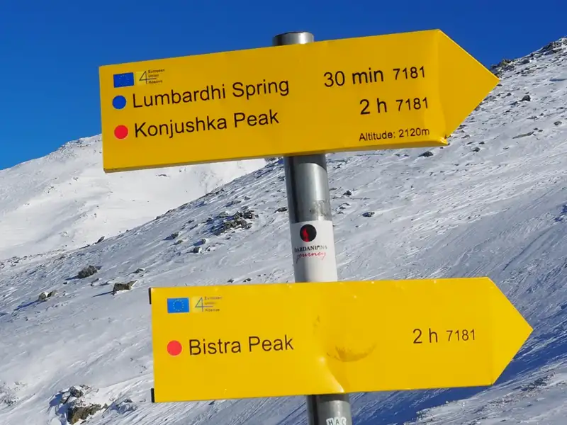 Wegweiser mit Richtungs- und Zeitangaben zu Lumbardhi Spring, Konjushka Peak und Bistra Peak in einer Höhe von 2120m.