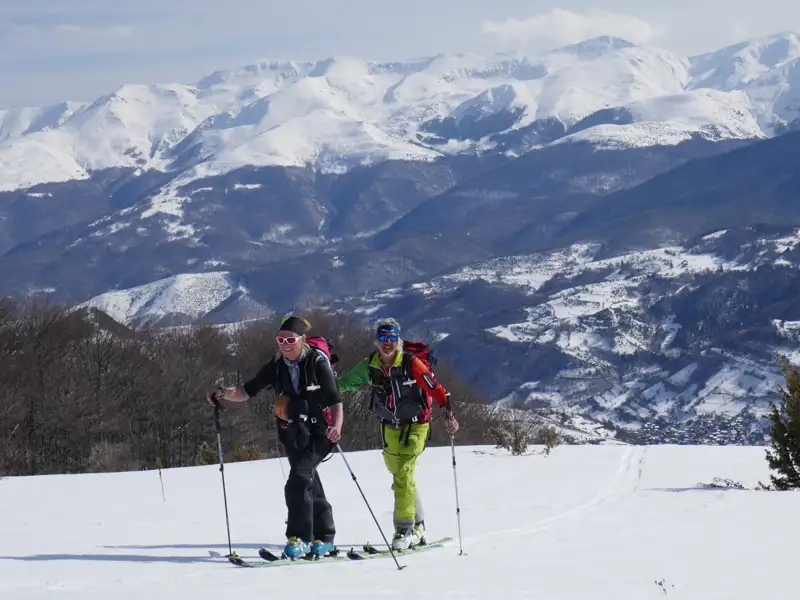 Zwei Skitourengeher auf einer Tour in den verschneiten Bergen.