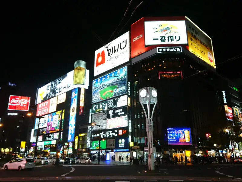 Leuchtreklamen in Susukino, Sapporo, Hokkaido, bei Nacht, mit Werbungen für Kirin Ichiban Shibori Bier und Sapporo Bier.