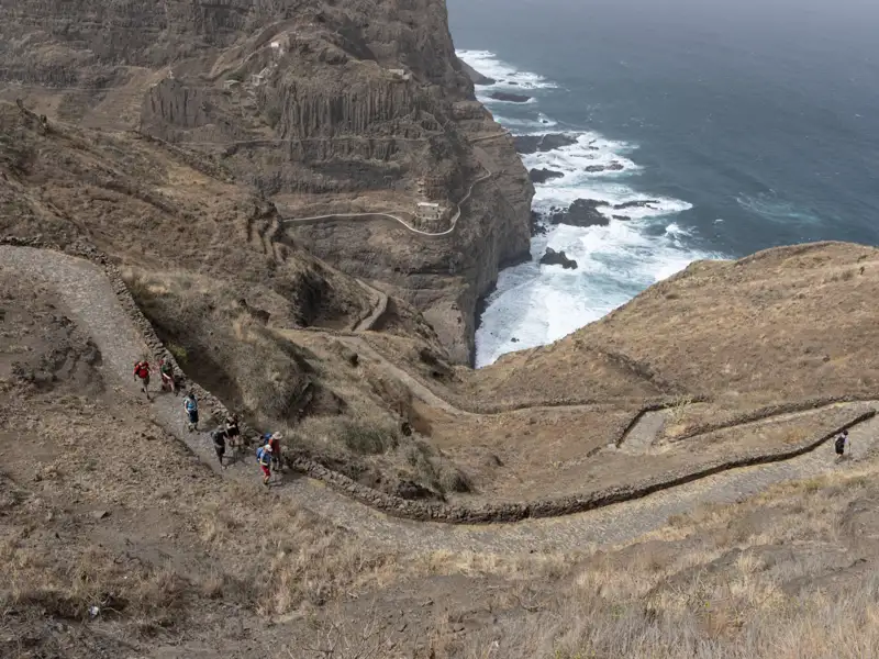 Wanderer auf einem steilen Küstenpfad.