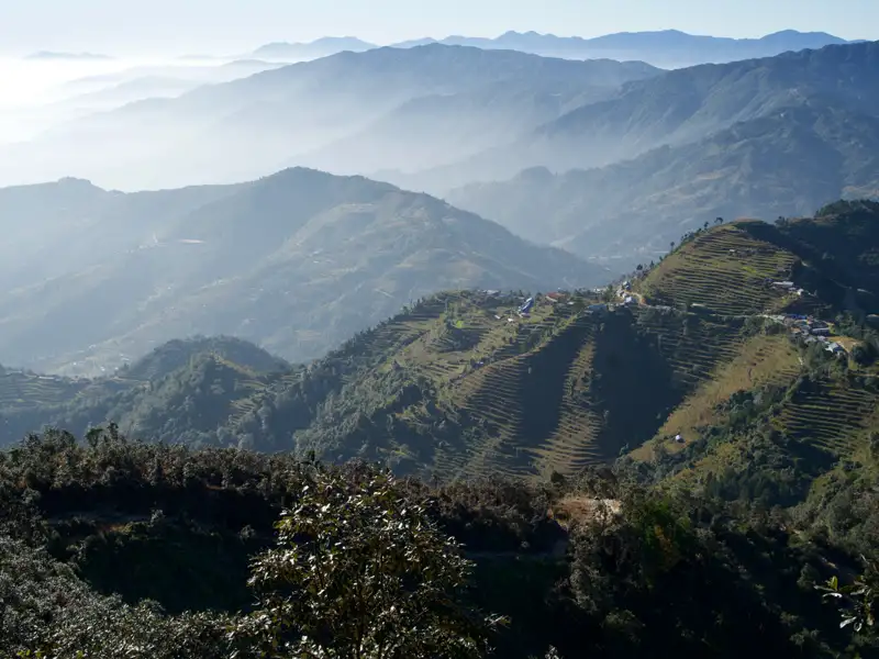 Terrassierte Hänge und ein Dorf in den Bergen.