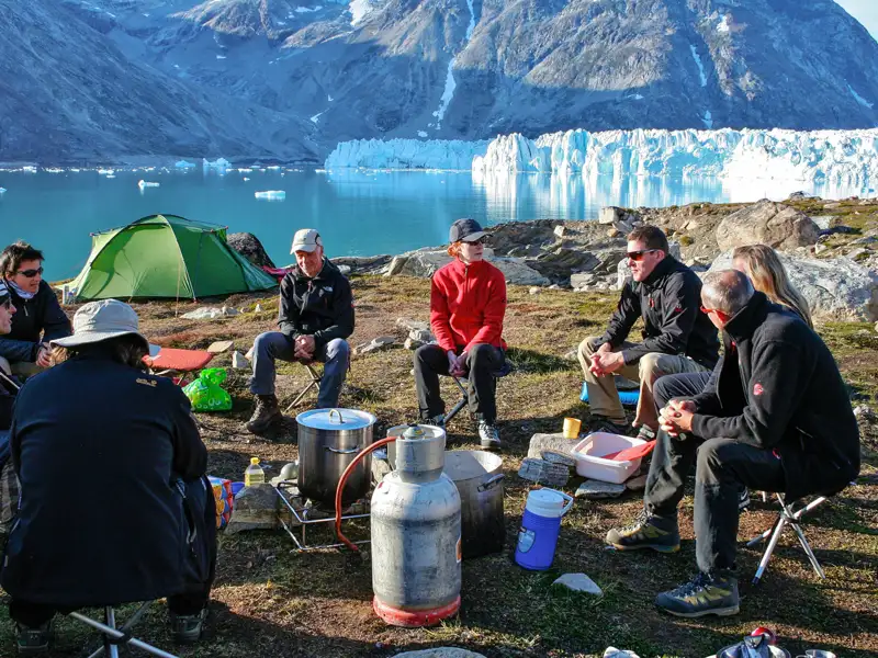 Reisende kochen und entspannen sich in der Nähe eines Gletschers während ihrer Reise.
