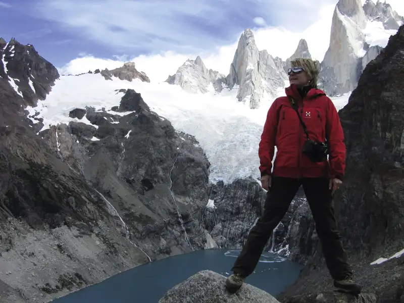 Wanderer vor Bergkulisse mit Gletscher und See.