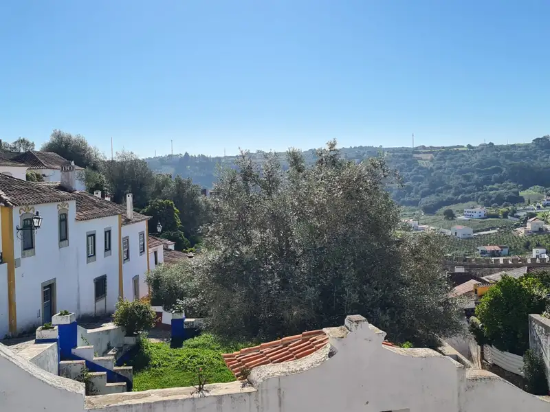 Blick auf eine hügelige Landschaft mit weißen Häusern und Ziegeldächern.