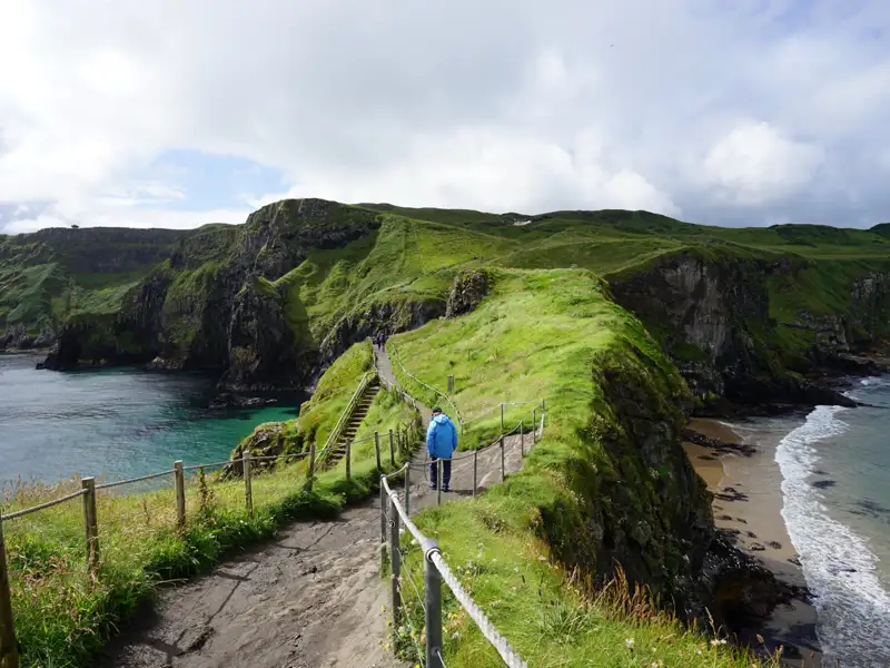 Wanderweg auf einer grünen Klippe entlang der Küste.