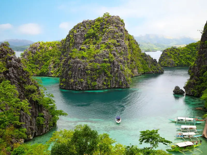 Bootstour durch die bewaldeten Kalksteininseln in türkisblauem Wasser.