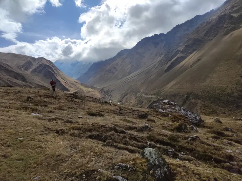 Wanderer auf einem Bergpfad in einem Gebirgstal.